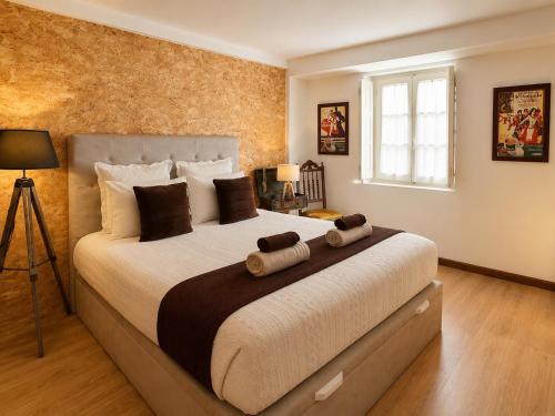 a bedroom with a large bed with two pillows at Casa do Criativo ® Bed&Breakfast in Almada