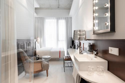 a hotel room with a sink and a bed at Ruby Louise Hotel Frankfurt by IHG in Frankfurt