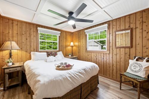 a bedroom with a large bed with a ceiling fan at Crystal Cabin on the Betsie in Thompsonville