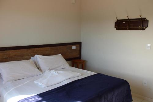 a bedroom with a bed with two white pillows at Summit Capitólio Hotel in Capitólio