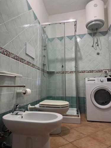 a bathroom with a shower and a toilet and a sink at Appartamenti Cala d'Ambra in San Teodoro