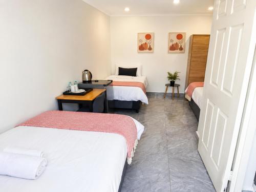 a hotel room with two beds and a desk at 60 On Kosmos in Bellville South