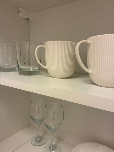 a shelf with cups and wine glasses on it at MartiniRoom Signature in Glauchau