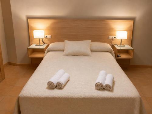 a bedroom with a large bed with two towels on it at Hotel Sierra de Huesa in Huesa