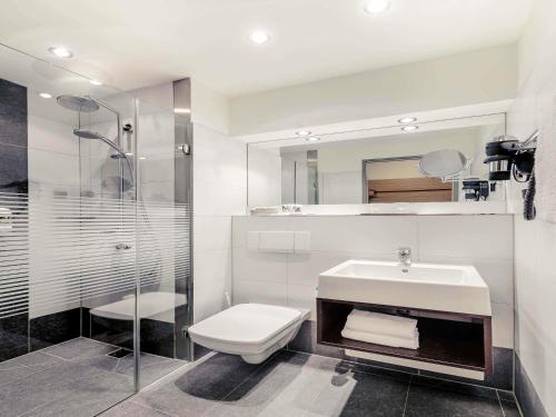 a bathroom with a toilet and a sink and a shower at Mercure Hotel Stuttgart Gerlingen in Gerlingen