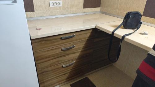 a kitchen with a counter with wooden cabinets and a counter at Casa Roxana in Constanţa