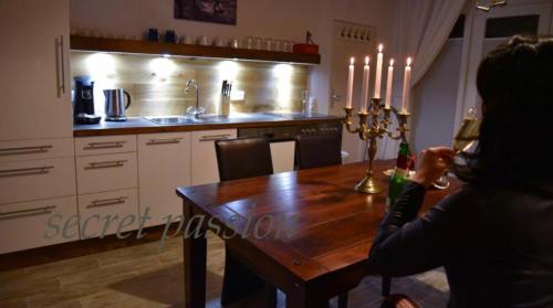 a woman sitting at a table with a glass of wine at Romantisches SM Apartment Secret Passion in Fehmarn