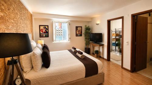 a bedroom with a bed with a teddy bear on it at Casa do Criativo ® Bed&Breakfast in Almada