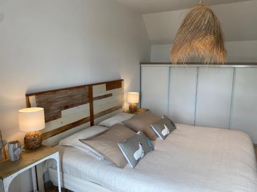 a bedroom with a large white bed with two lamps at LES POIS SONT ROZ in Perros-Guirec