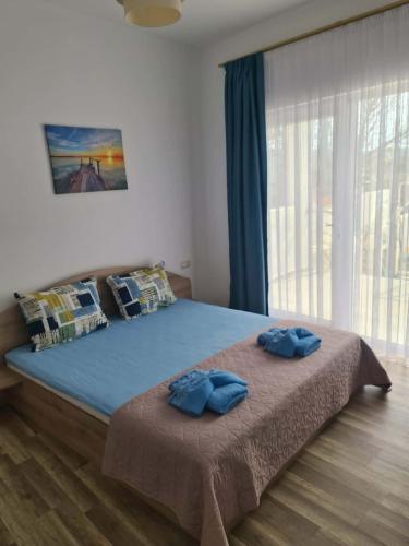 ein Schlafzimmer mit einem großen Bett und zwei blauen Kissen in der Unterkunft Villa ASTERA in Pefkari