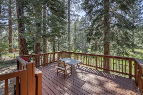 a wooden deck with a table and a chair on it at Tahoe Forest Haven in South Lake Tahoe