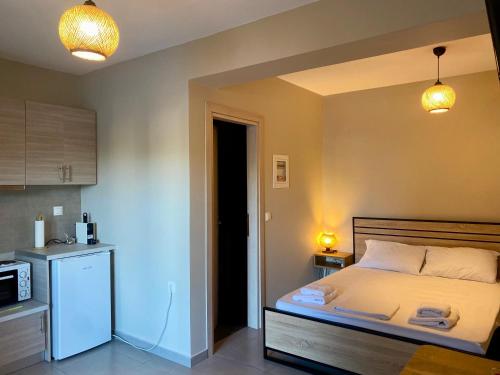 a small bedroom with a bed and a kitchen at Regium Studio in Nikiana
