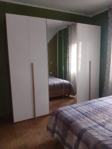a bedroom with white cabinets and a bed with a mirror at Casa Rosa in Vigevano