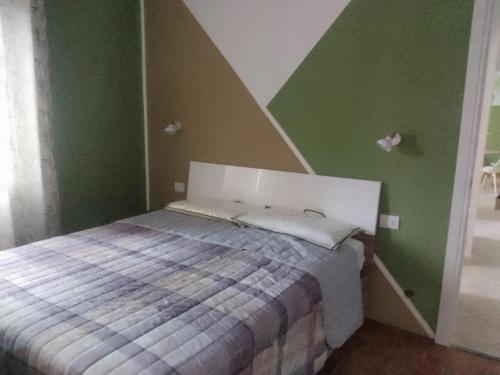a bed in a room with green walls at Casa Rosa in Vigevano