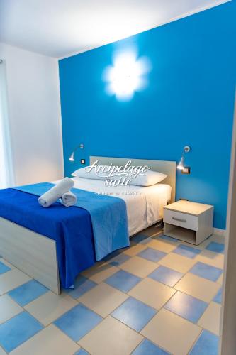 a blue bedroom with a bed and a blue wall at Arcipelago Suite in Belvedere Marittimo