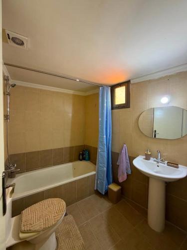a bathroom with a tub and a sink and a toilet at Batroun sunset guesthouse in Batroûn