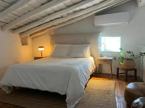 a bedroom with a white bed and a window at Alegrete Castle House by NaturAlegre in Alegrete