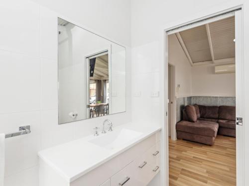 a bathroom with a sink and a mirror at Wairo Beach Holiday Park in Lake Tabourie