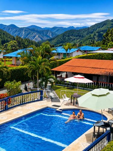 a pool at a resort with mountains in the background at Complejo Campestre Salome Cabañas & Hotel in Calima