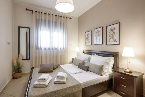 a bedroom with a bed with two towels on it at IFESTOS APARTMENTS in Ierissos