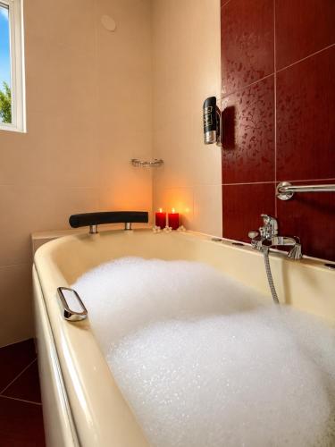 a bath tub in a bathroom with a mirror at Hotel Neptun Gradac in Gradac