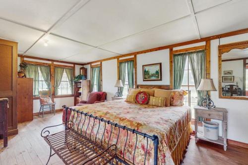 a bedroom with a bed in a room with windows at Historic Lakefront & Wildlife Haven with Firepit & Gas Grill - Minutes to Water in Burnet
