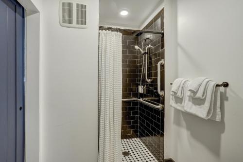 a bathroom with a shower with black tiles at Gravity Haus Breckenridge in Breckenridge