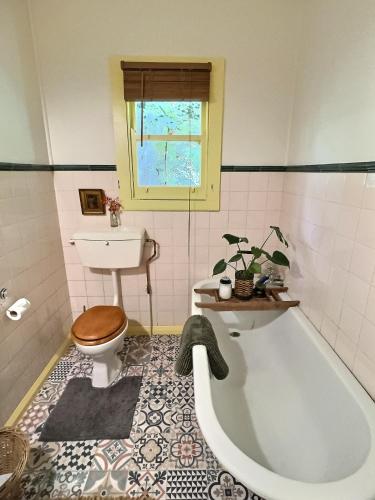a bathroom with a tub and a toilet and a sink at The Rabbiter's Cottage in Kahuranaki