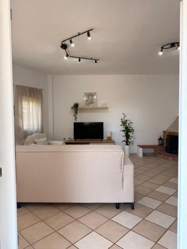 a living room with a couch and a tv at The Family Villa in Tragasiá