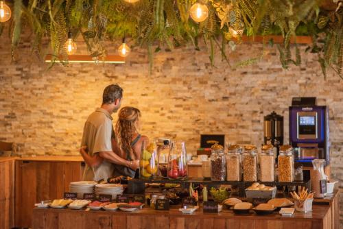 a man and woman standing behind a counter with food at Hotel Mae in Maitencillo