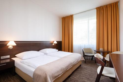 a hotel room with a bed and a table and chairs at Hotel Tatra in Bratislava