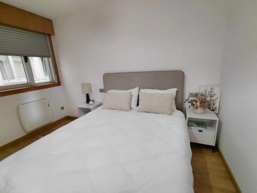 a bedroom with a large white bed with two pillows at Brisas de Malpica in Malpica