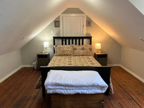 a bedroom with a bed with two night stands and two lamps at Quaco Cottages-The Shipbuilder's Summer Kitchen in Saint Martins