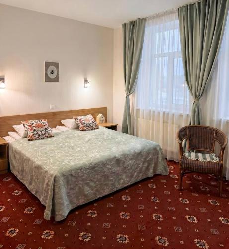 a bedroom with a bed and a chair and a window at Annabella in Riga