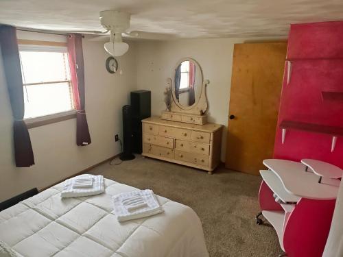 a bedroom with a bed and a mirror and a dresser at Del La Rose in Clarksburg
