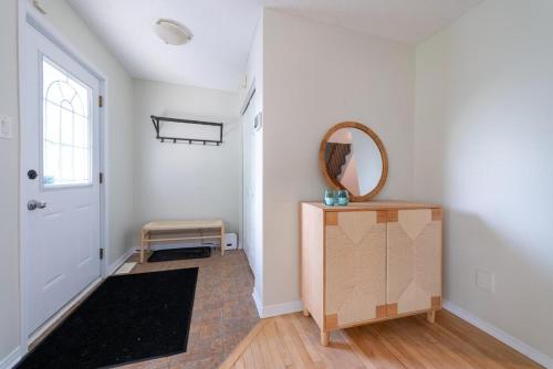 a hallway with a door and a mirror on the wall at Pool, BBQ & Foosball Spacious 4BR Home in Gatineau