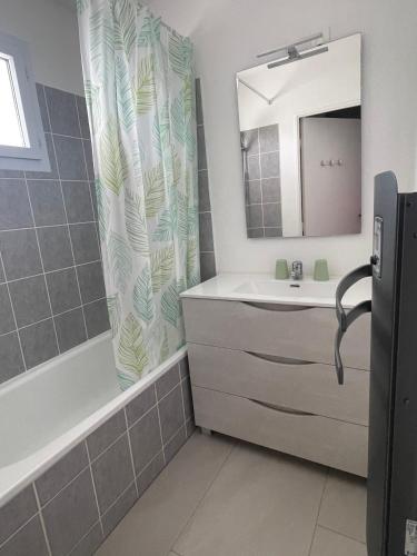 a bathroom with a sink and a shower curtain at Le cocon de Marennes in Marennes