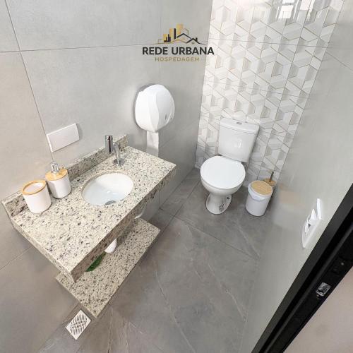 a bathroom with a toilet and a sink at Loft 10 com ar-condicionado da Rede Urbana in Indaiatuba