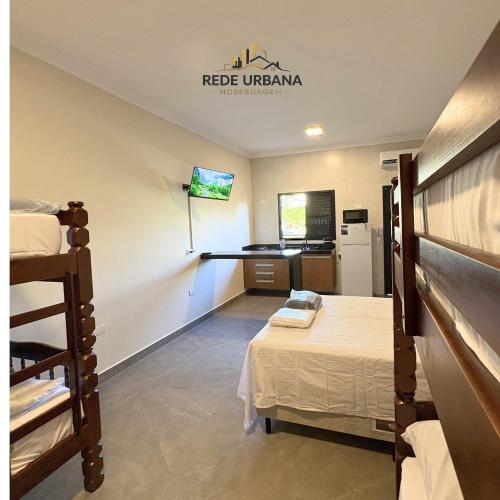 a room with two bunk beds and a kitchen at Loft 10 com ar-condicionado da Rede Urbana in Indaiatuba
