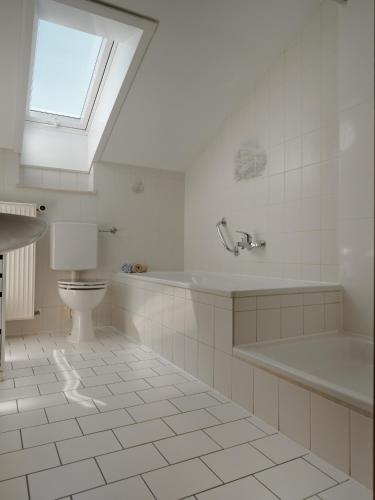 a white bathroom with a toilet and a sink at Gschwingerhof in Riedering