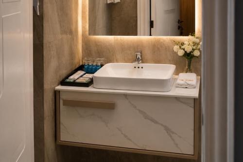 a bathroom with a white sink and a mirror at The Alima Suites in Accra
