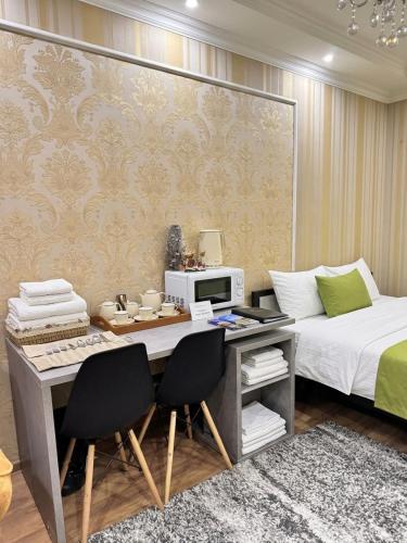 a bedroom with a bed and a desk with two chairs at Stefan 64 in Chişinău