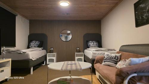 a room with two beds and a couch and a table at Karlskrona in Rödeby