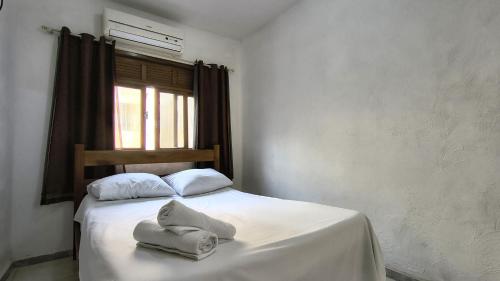 a bedroom with a bed with two towels on it at Hotel Silveira in Guarapari