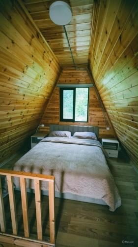 a bedroom with a bed in a wooden cabin at Bujtina Panorama Kir in Kashec