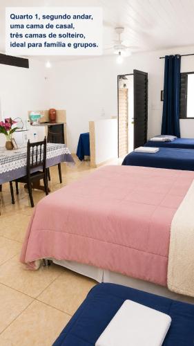 a room with three beds with blue and pink sheets at Pousada das Estrelas - Centro de Conservatória - rua principal in Conservatória