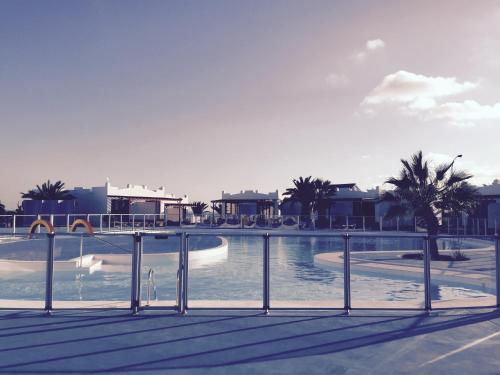 una piscina en un complejo con palmeras en Sun Beach Apartamento nº 26, en Caleta de Fuste
