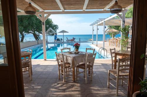 a table and chairs with a view of a swimming pool at Mesogios Beach in Kissamos