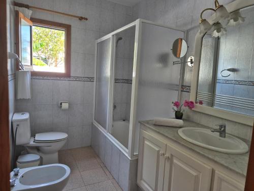 a bathroom with a sink and a toilet and a mirror at Villa familiar con piscina privada en Calan Blanes in Cala en Blanes