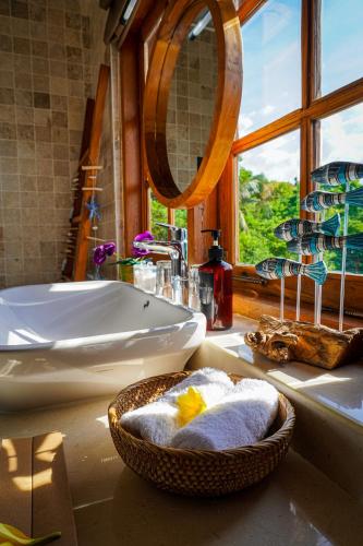 a bathroom with a sink and a bowl of towels at Villa Kampung Kecil Beach Front in Kubu